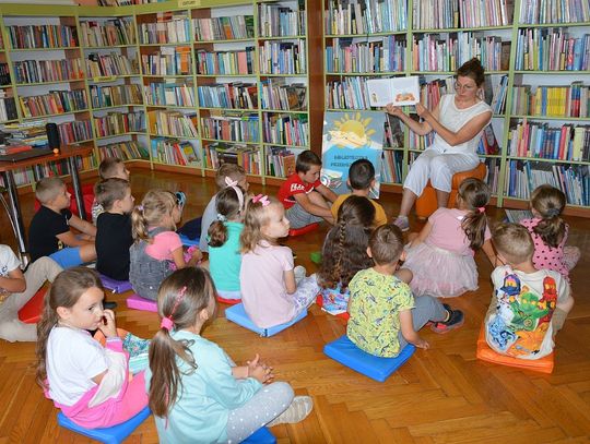 bibliotekarka pokazuje dzieciom książkę