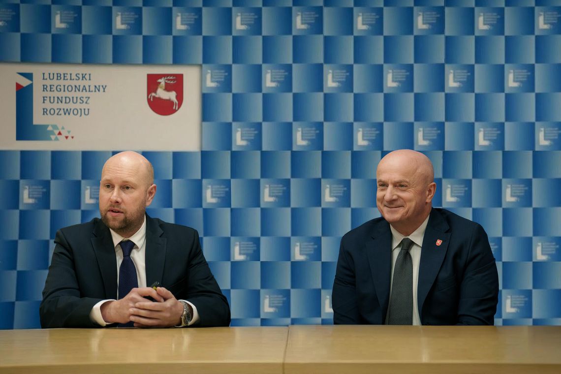 5 lat napędzania lubelskiego biznesu. Kapitał zostaje w regionie i stale pracuje Prezes Zarządu LRFR Rafał Langiewicz oraz Marszałek Województwa Lubelskiego Jarosław Stawiarski siedzący przy stole na tle niebieskiej ścianki prasowej Lubelskiego Regionalnego Funduszu Rozwoju