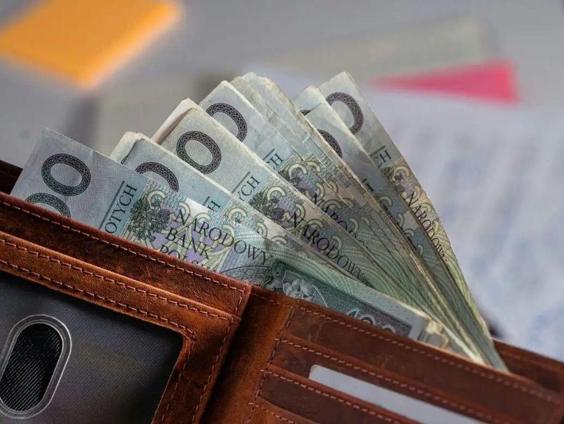 portfel z wystajacymi stówkami