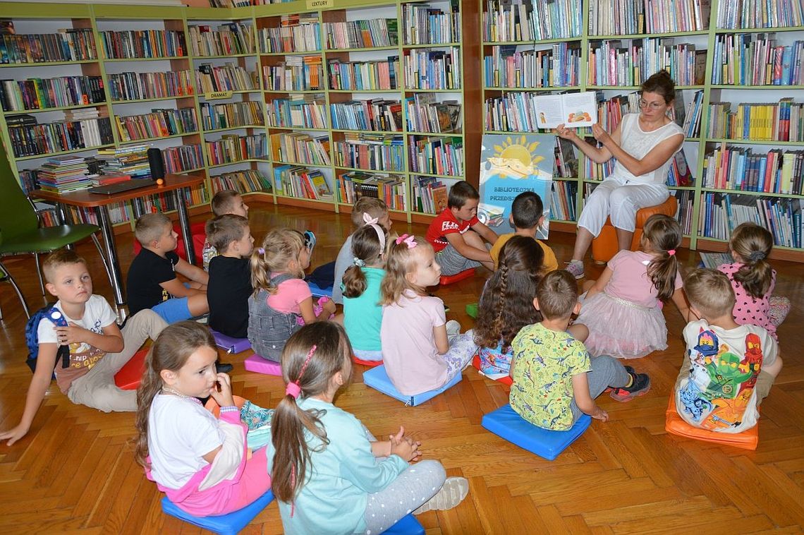 bibliotekarka pokazuje dzieciom książkę