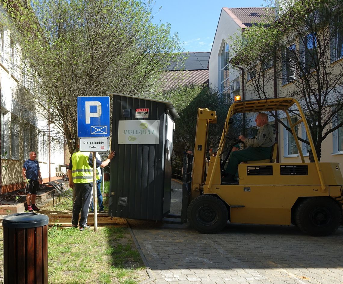 przenosiny lodówki, regału i drewnianego domku przed budynek urzędu miejskiego we włodawie