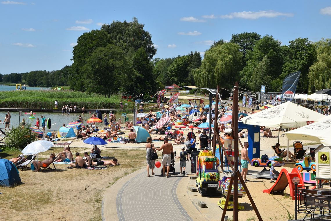 widok na plażę z turystami nad jeziorem białym w okunince